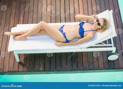 Beautiful Woman In Blue Bikini Lying On Sun Lounger By Poolside Stock