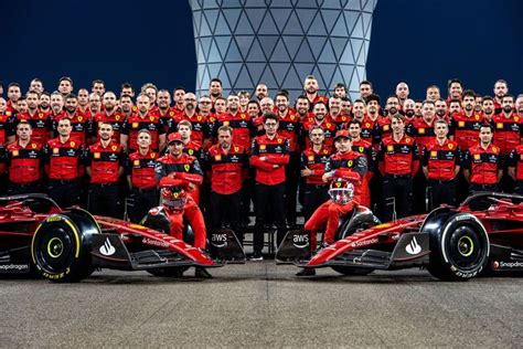 The Ferrari Team Poses For A Group Photo In Front Of Their New Car At