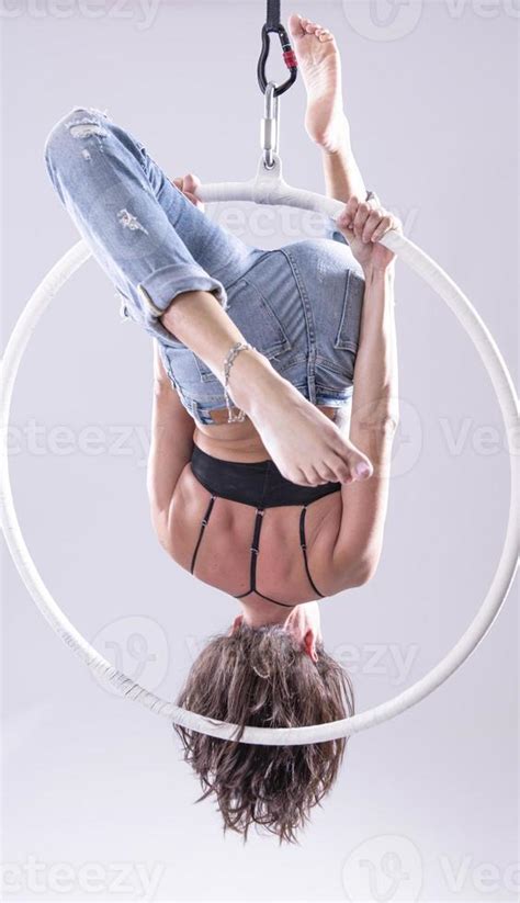 A female Aerial hoop gymnast performing exercises on an Aerial hoop ...