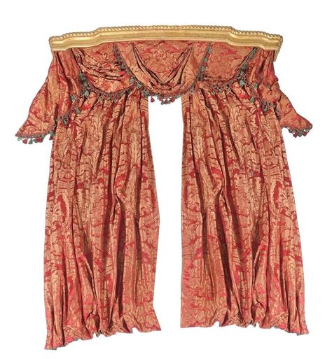 An Orange And Red Curtain With Tassels Hanging From It S End