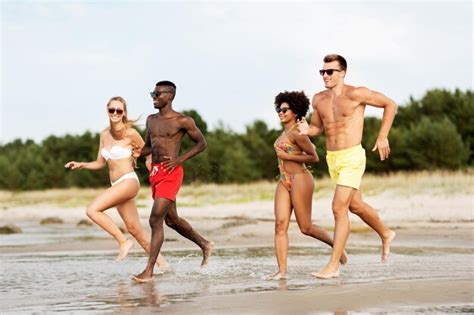 Amigos Felices Corriendo En La Playa De Verano Foto Premium