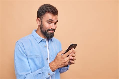 Der zufriedene bärtige mann lächelt glücklich während er auf dem