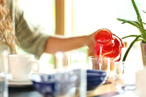 Una Mujer Que Llena El Vaso Con Agua En Un Restaurante Imagen De