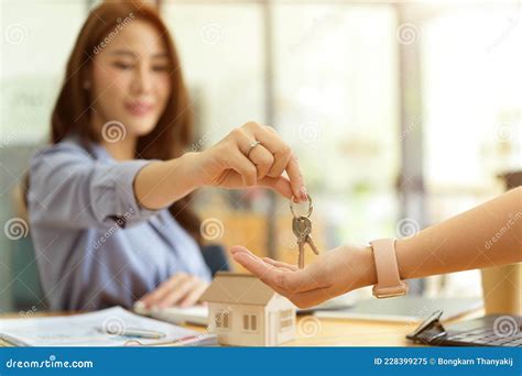 Female Real Estate Agent Giving A House Key To New Owner Stock Image