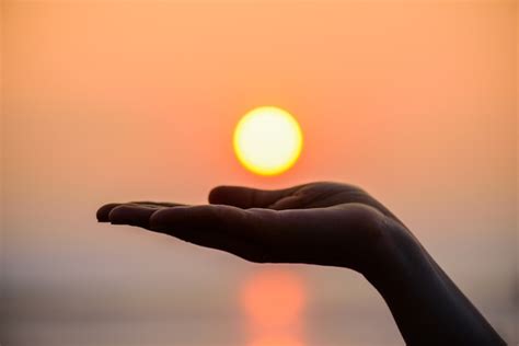 Close Up And Silhouette Of Hand Holding Sun Sun On Woman Hand