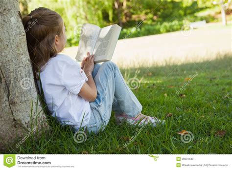 Vista Traseira Do Livro De Leitura Da Menina No Parque Imagem De Stock