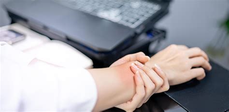 Asian woman holding her sore hand on wrist close-up. Pain from using