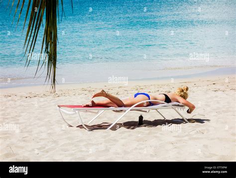 Portrait d une femme blonde des bains de soleil sur la plage à côté de la mer des Caraïbes