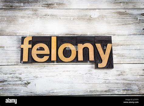 The Word Felony Written In Wooden Letterpress Type On A White Washed