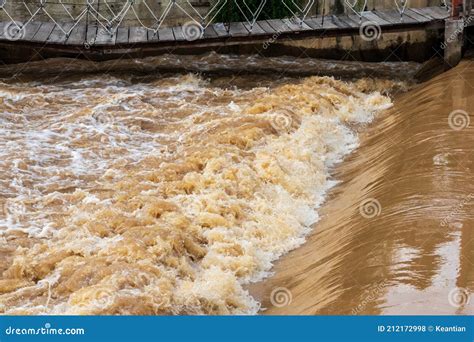 El Agua Turbia Se Precipit Sobre El Vertedero Bajo El Puente Colgante