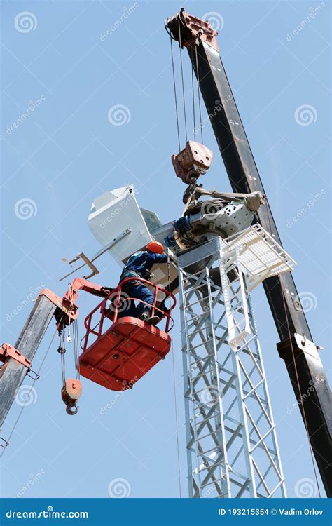 Workers On The Aerial Platform With The Help Of A Crane Carry Out The