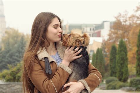 La Fille Tient Un Petit Chien Dans Des Ses Bras étreintes Et L