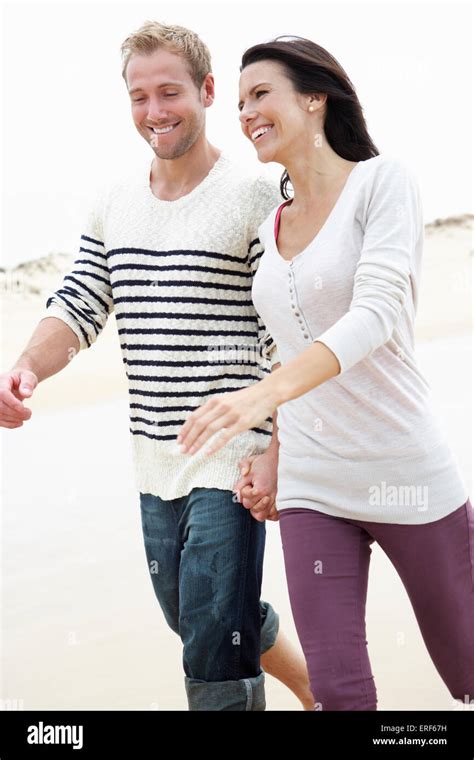 Couple Walking Along Beach Together Stock Photo Alamy