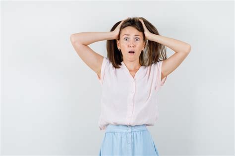 Mujer Joven En Camiseta Falda Manteniendo Las Manos En La Cabeza Y