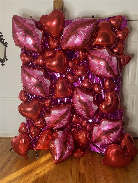 A Bunch Of Heart Shaped Balloons Sitting On Top Of A Wooden Floor