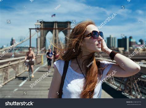 Cute Girl In Sunny Windy Day Walking On Brooklyn Bridge Stock Photo