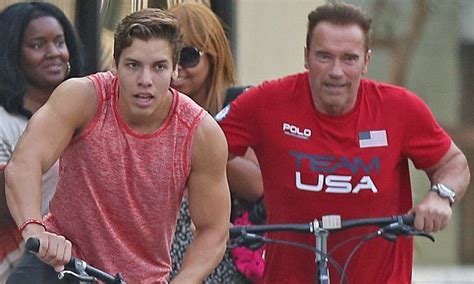 A Man Riding A Bike Next To A Woman On A Street With Other People