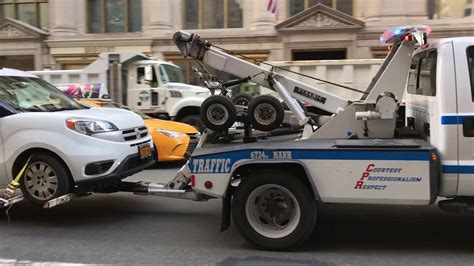 Nypd Tow Truck Towing A Car On 5th Avenue In The Midtown Area Of