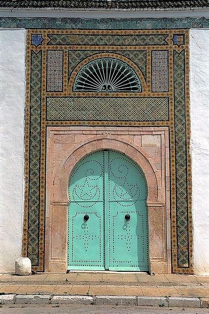 An Old Building With Two Large Blue Doors