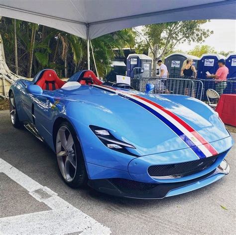 A Blue Sports Car With Red White And Blue Stripes On The Hood Parked