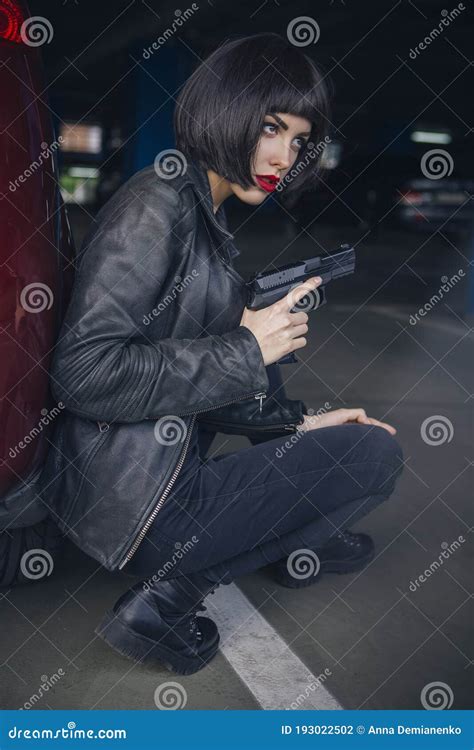 Beautiful Brunette Spy Agent Killer Or Police Woman In Leather Jacket And Jeans With A Gun In