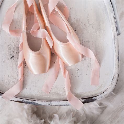 Pink Ballet Pointe Shoes And Feather On White Wood Background Stock