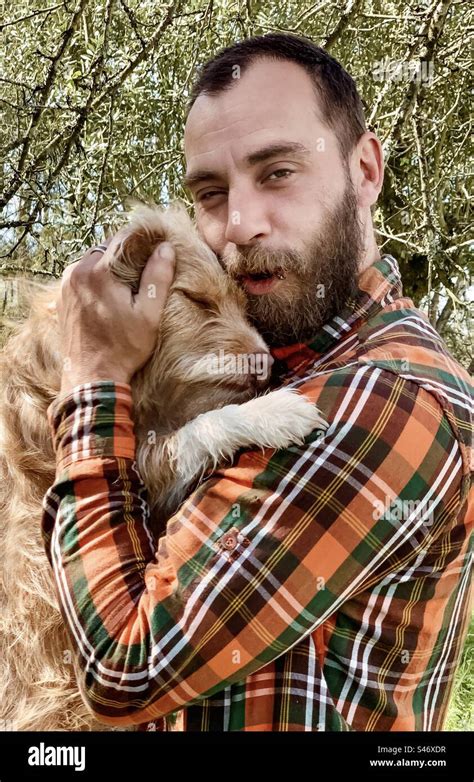 A Dog Snuggles Into Her Owners Chest Stock Photo Alamy