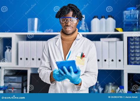 African American Man Scientist Using Touchpad At Laboratory Stock Photo