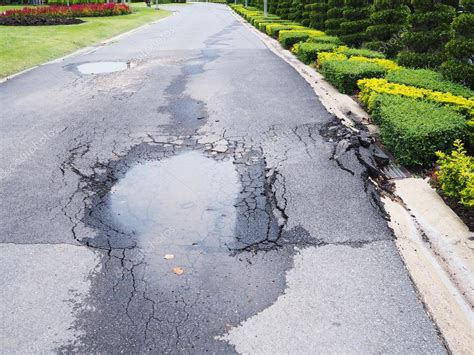 Potholes on damaged asphalt road Stock Photo by ©P.Kanchana 122870358