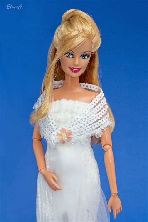 A Doll With Blonde Hair Wearing A White Dress