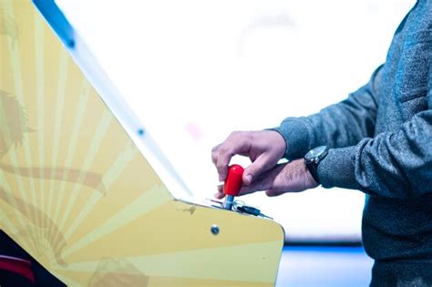 Premium Photo A Man Plays A Game With A Yellow And White Pinball Machine