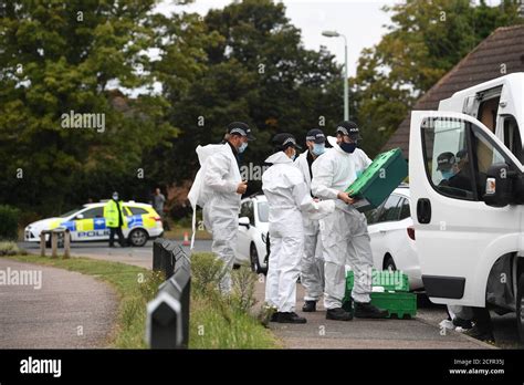 Suffolk Police Officers Put On Forensic Suits Near To The Scene On