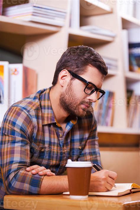 Spending Time In Library Confident Young Man Writing Something In Note