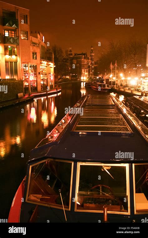 Canal with tour boat at night in Amsterdam,Holland Stock Photo - Alamy