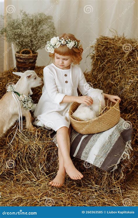 Une Jolie Petite Fille Est Assise Dans Le Hayloft Avec Un Lapin Image