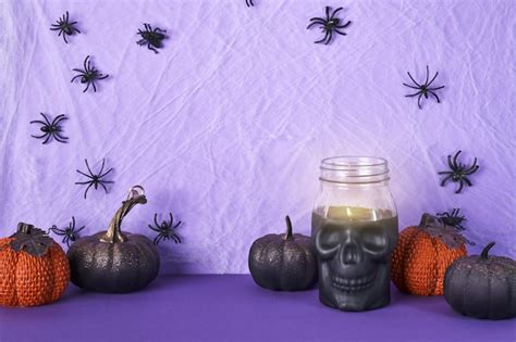 Premium Photo Skull Candle Black Pumpkins And Cobweb With Spiders On Purple Background