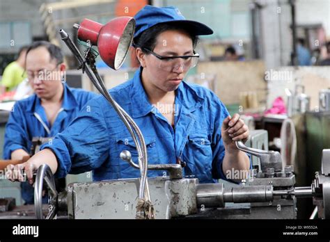 Chinese workers manufacture steel products at a factory in Qiqihar city ...