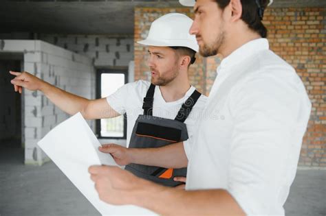 Male Architect Giving Instructions To His Foreman At Construction Site