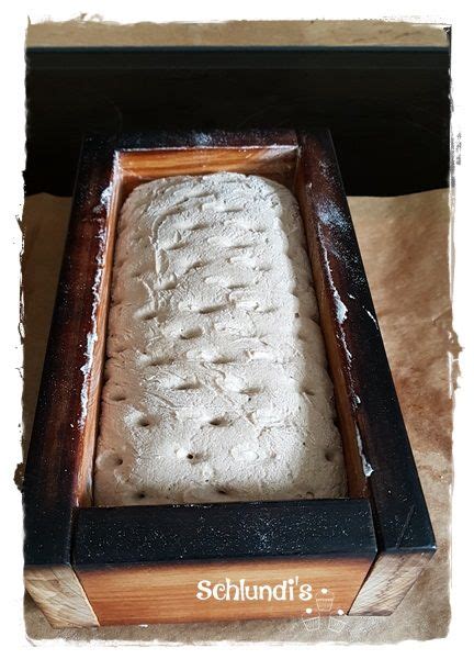 A Loaf Of Bread Sitting In A Wooden Box On Top Of A Table With The Word