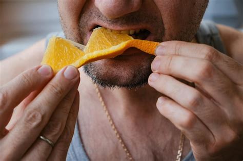 Premium Photo Unrecognizable Middleaged Man Eating An Orange Slice