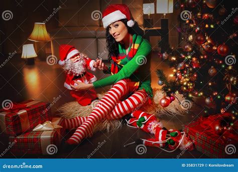 Beautiful Woman Santa Helper Next To Christmas Tree Stock Image