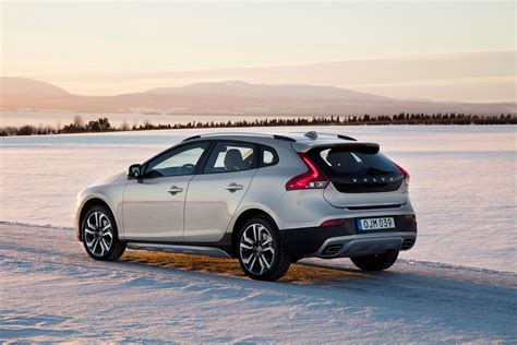 A Silver Car Parked On The Side Of A Road In The Middle Of Snow Covered