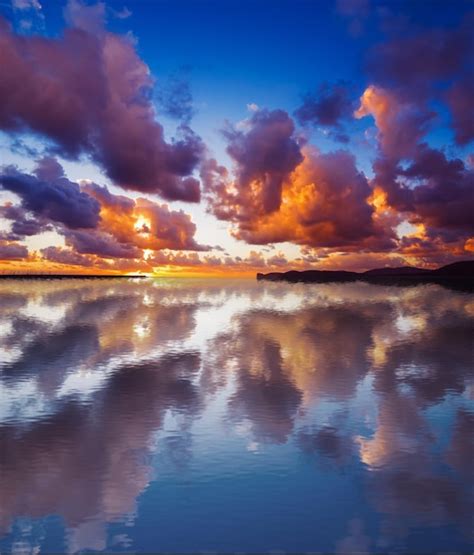 Premium Photo Dramatic Sky Reflected In The Water At Sunset