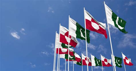 Pakistan And Greenland Flags Waving Together In The Sky Seamless Loop