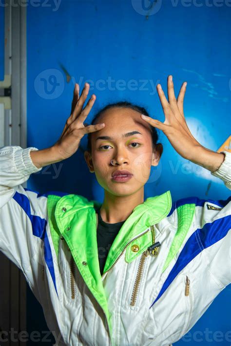 A Gay Asian Man Posing In A Tracksuit In Front Of A Blue Locker Stock Photo At Vecteezy