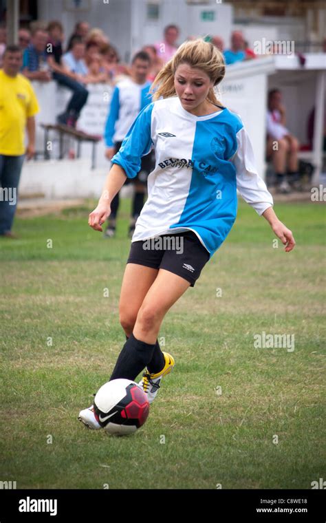 A sports team football match showing a young girl playing football for ...