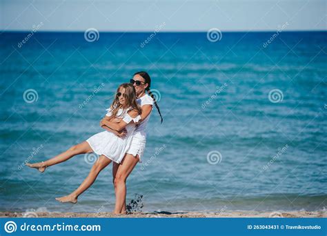 Young Happy Mother And And Her Daughter Having Fun On The Beach Stock