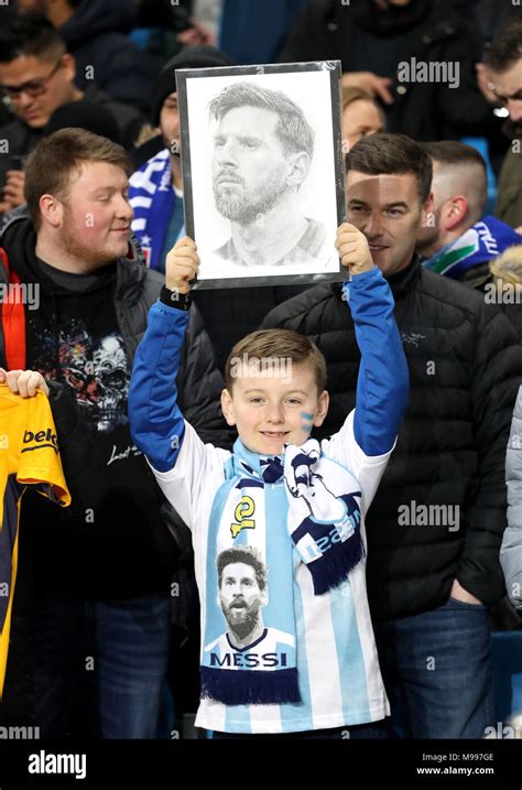 A young Argentina fan in the stands holds up a drawing of Lionel Messi ...