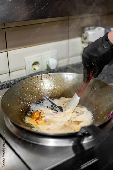 Professional chef cooking chicken curry food in wok pan on kitchen ...