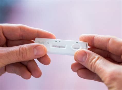 Close Up Woman Hands Holding Rapid Covid 19 Test With A Positive